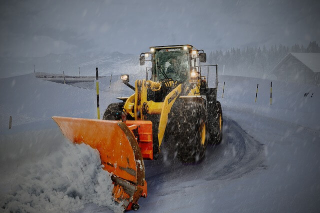 Snow Removal Company Names: a tractor removing snow from road